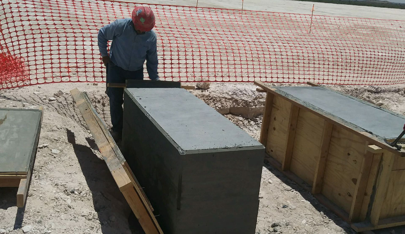 man measuring a concrete foundational pillar for W5 Construction services for heavy industrial